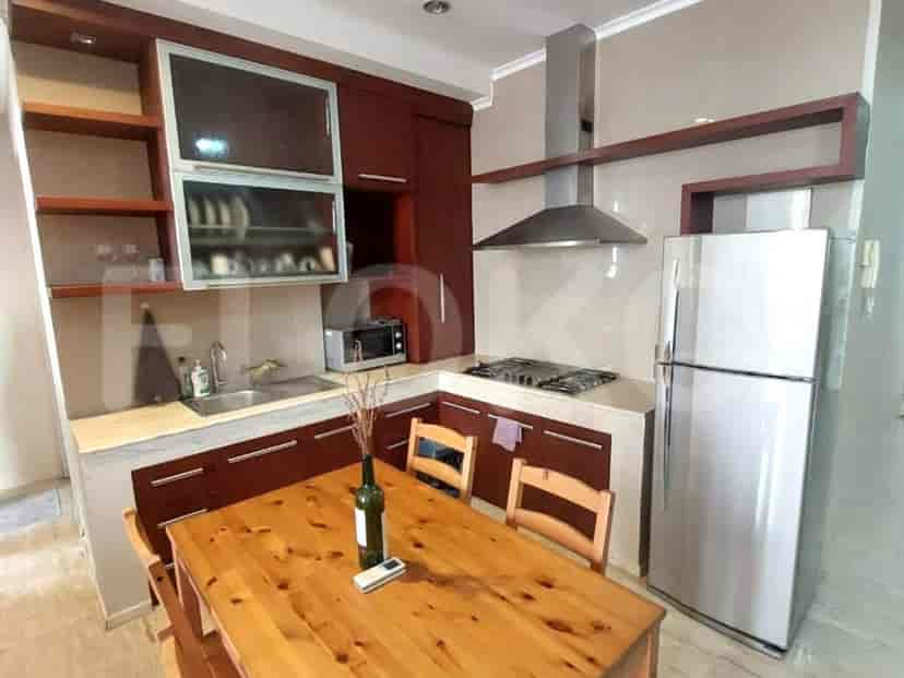 A well-equipped kitchen with wooden cabinets, a gas stove, and a dining table.