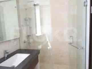Kamar mandi modern dengan pancuran berkaca, meja rias, dan toilet.
