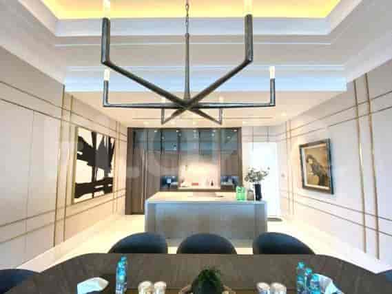 A luxurious dining area with a chandelier and a kitchen at the back.