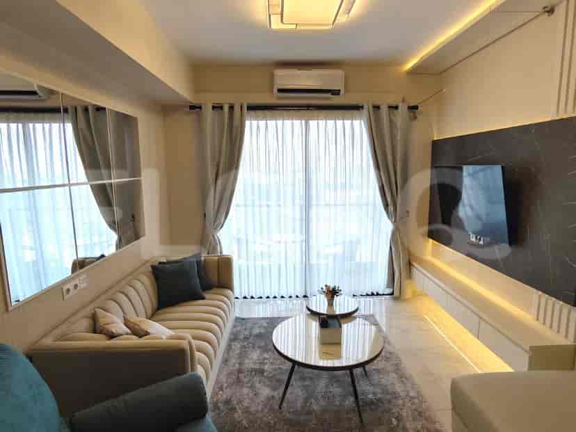 A stylish living room with a comfortable sofa, a wall-mounted TV, and large windows.
