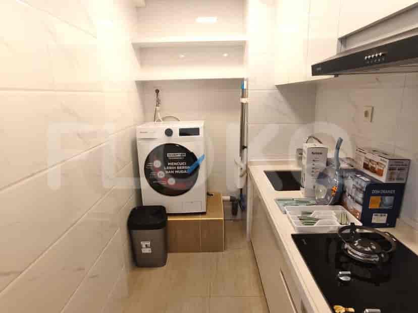A compact kitchen with a washing machine and modern appliances.
