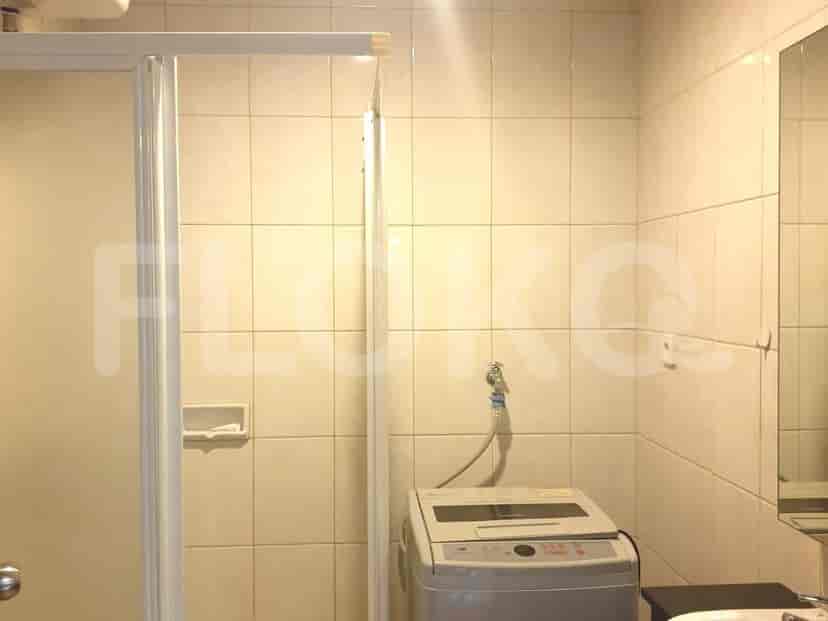 Kamar mandi dengan mesin cuci, wastafel, dan pancuran.