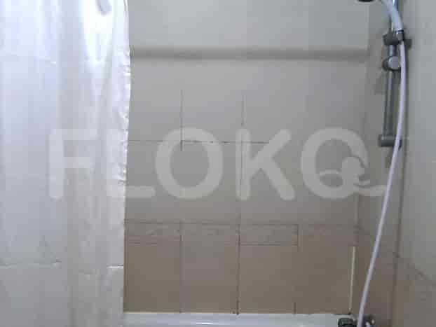 A shower area with a curtain and shower head.