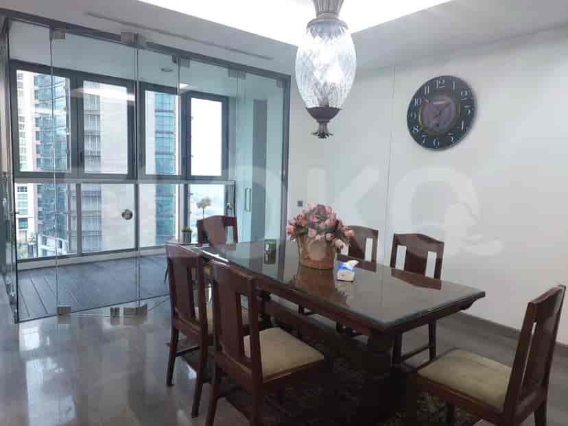 A well-lit dining room with a wooden dining table and large window.
