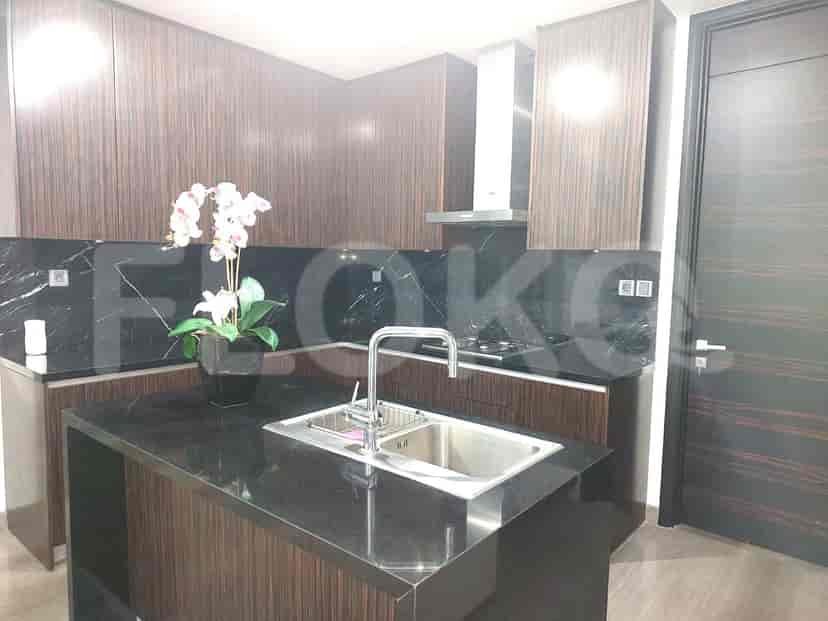 A modern kitchen with dark cabinetry and a black countertop.