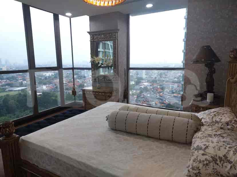 A master bedroom with a bed, mirror, and city view.