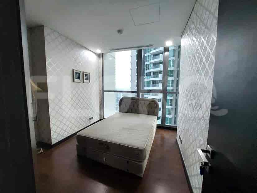 A small bedroom with a bed and a window.