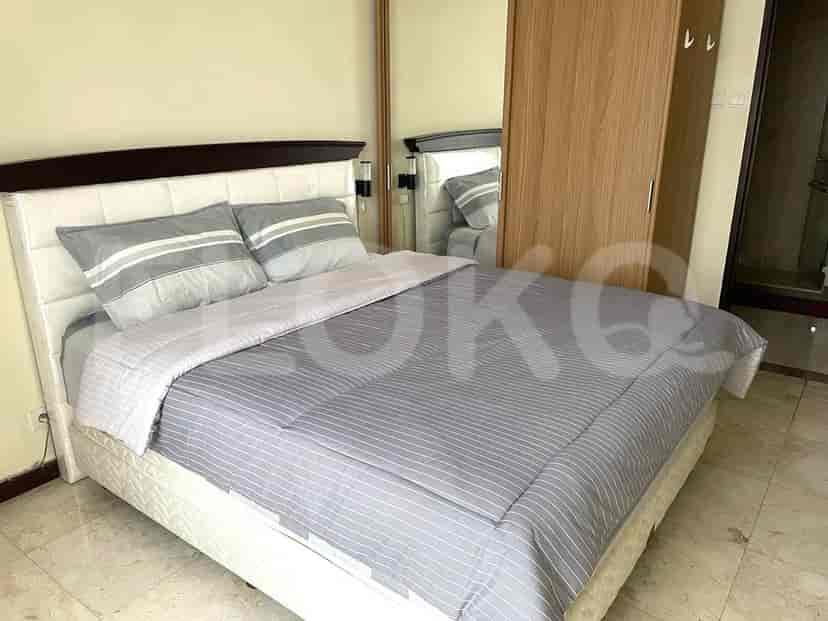 Bedroom with bed, mirrored closet, and side table.