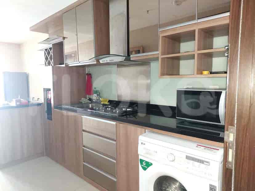 A modern kitchen equipped with stainless steel appliances, dark countertops, and wooden cabinets.