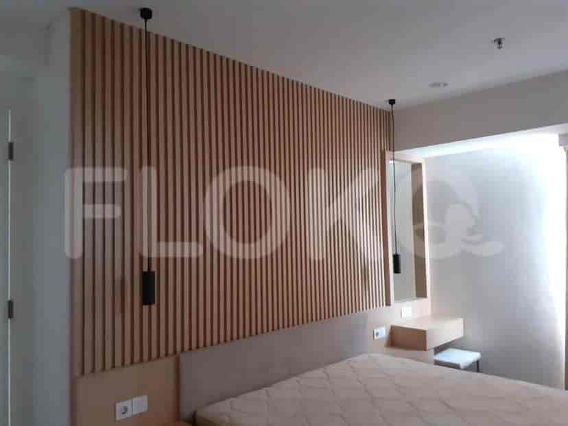 Bedroom with a wooden wall panel, bed, and built-in closet.