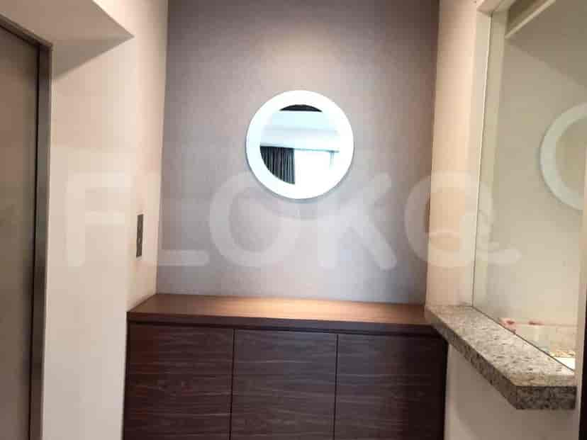 A bedroom featuring a circular mirror above a cabinet.