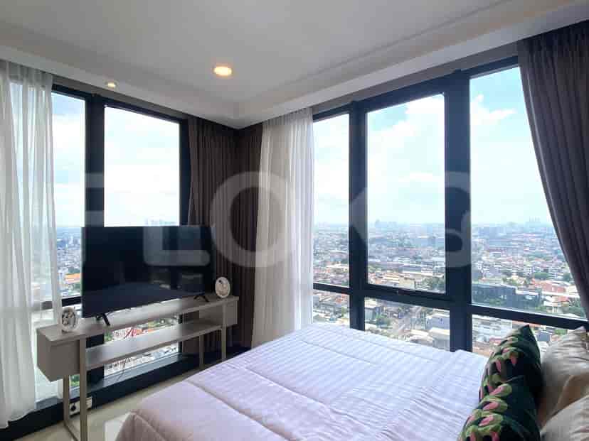 Bedroom with a large window, bed, and a TV.