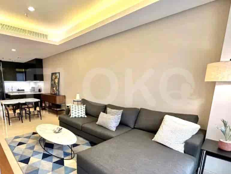 Living room with a grey L-shaped sofa, oval coffee table, and a view of the dining area.