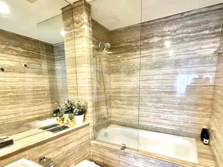 Bathroom with a bathtub, shower, and mirror.