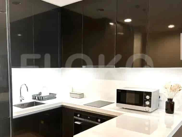 Modern kitchen with black cabinets, white countertops, and a microwave.