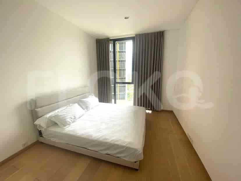 Kamar tidur modern dengan tempat tidur profil rendah dan lantai kayu.