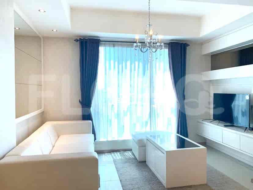 A modern living room featuring a comfortable seating area and large windows.