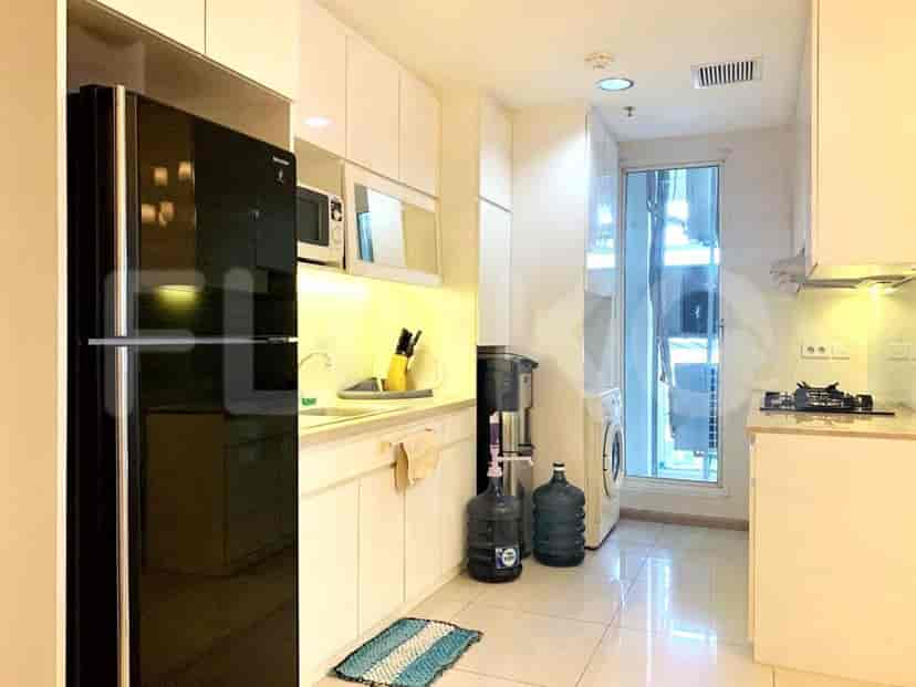 A modern kitchen with white cabinets, a black refrigerator, and stainless steel appliances.