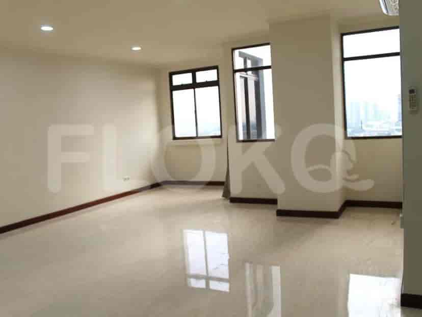 An empty living room with large windows and a shiny floor.