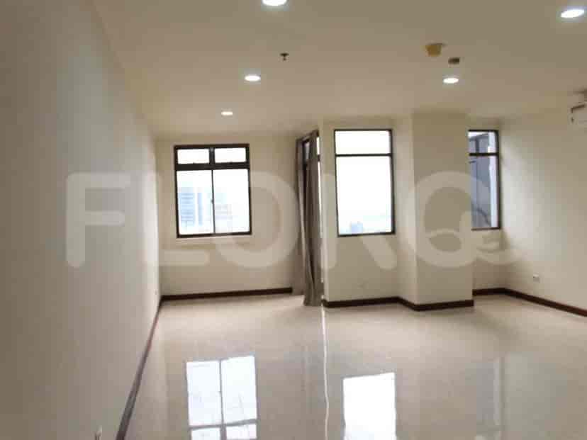 An empty living room with large windows and a shiny floor.