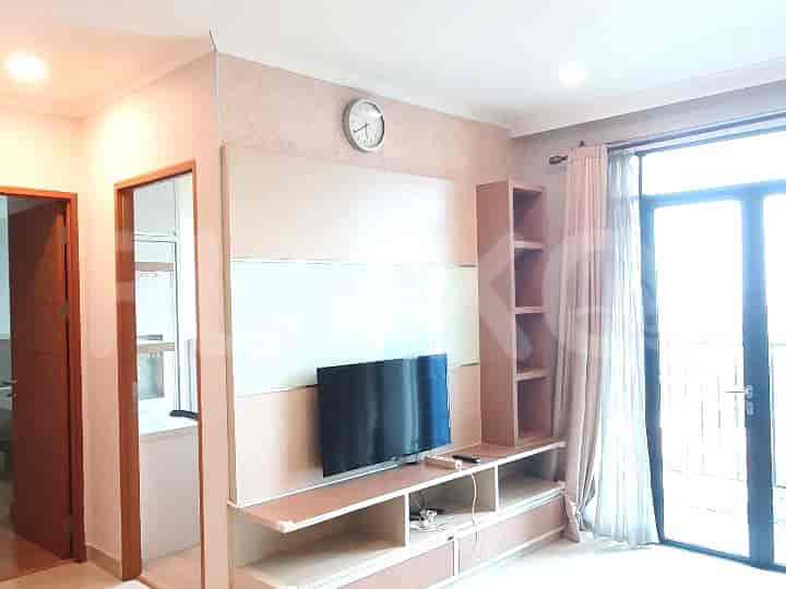 Living room with TV, shelves, and access to the balcony.