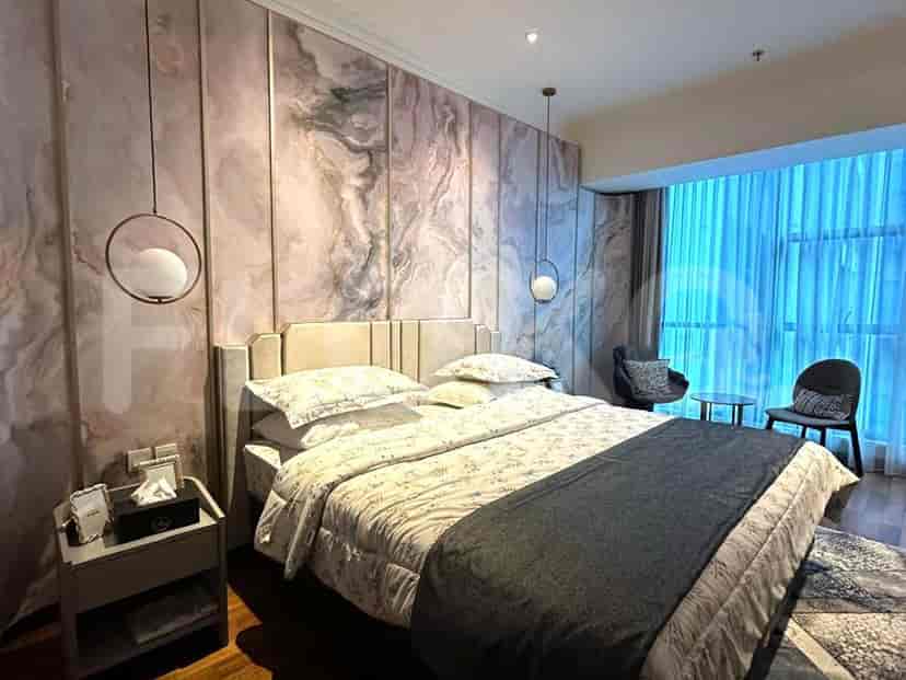 Bedroom with marble accent wall, king bed, and stylish pendant lights.