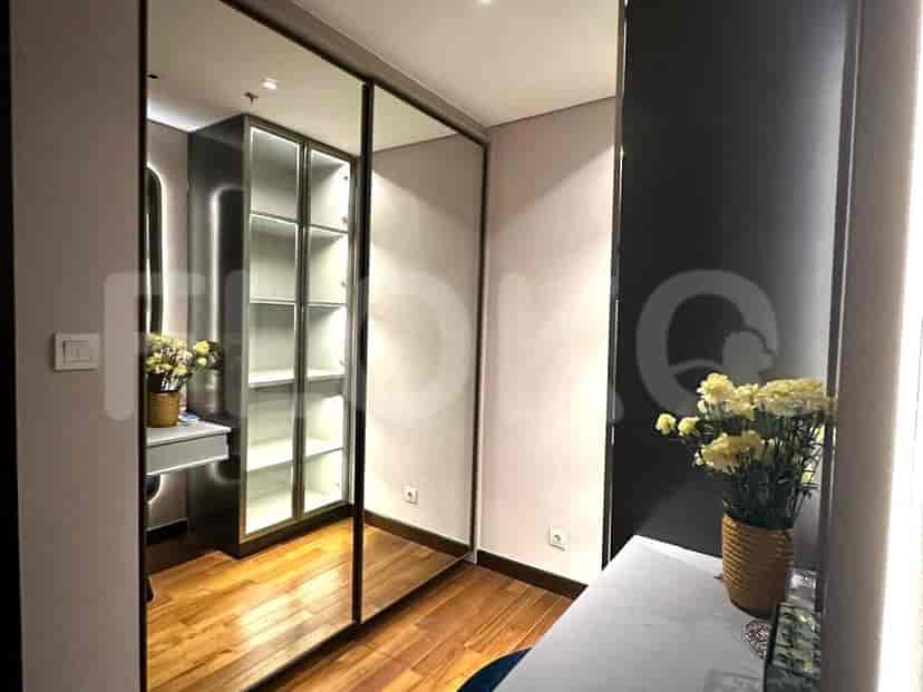 Walk-in closet with mirrored doors, shelves and a dressing table.