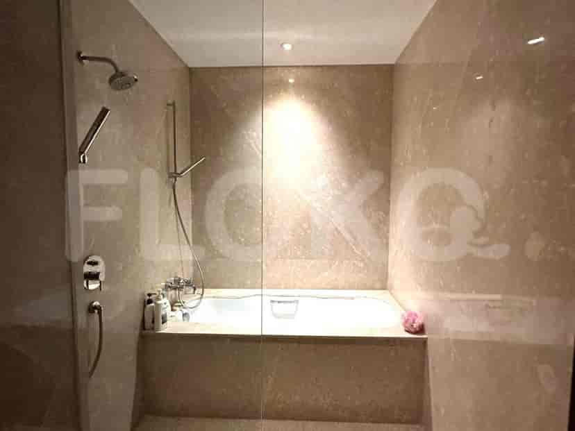 Bathroom with a bathtub, shower, and marble walls.