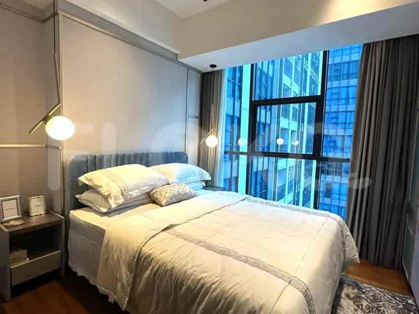 Bedroom with blue accents, large windows and simple decor.