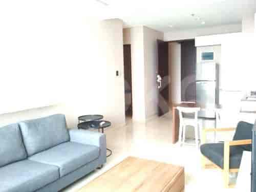 Ruang tamu dengan sofa, dan pemandangan ke area dapur.