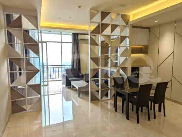Open-plan living and dining space with a dining table, sofa, and decorative divider.