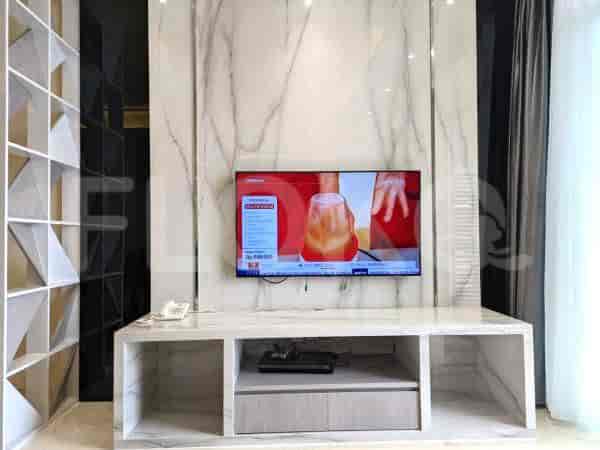 Living room with a TV mounted on a marble panel and a storage unit.