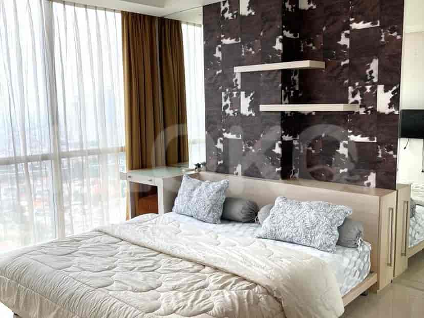 Modern bedroom with a bed, a desk, and window curtains.