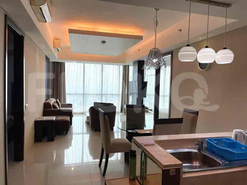 Open floor plan showcasing living, dining, and kitchen areas. Features pendant lights, dining table with chairs, and a view of the city.
