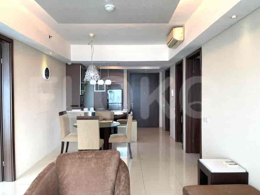 Combined living, dining, and kitchen space. Includes a round dining table, pendant lighting, and white walls.