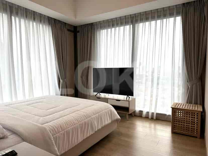 Kamar tidur yang menampilkan tempat tidur besar dengan gorden dan TV.