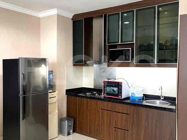 A modern kitchen with a refrigerator, stove, and upper cabinets.