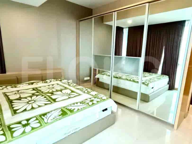 Bedroom with a large bed and mirrored closet doors.