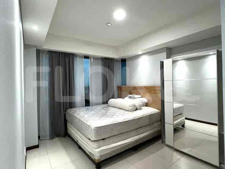 A master bedroom with a queen-sized bed, sliding closet and full-length mirror.