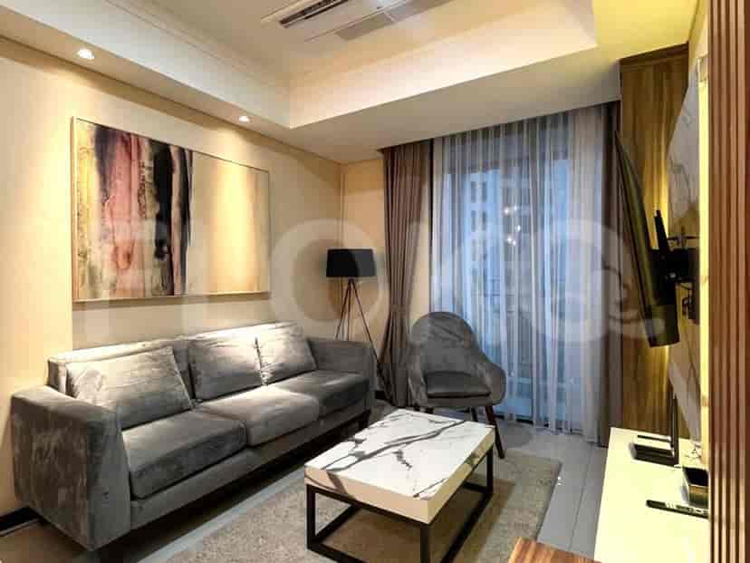 A modern living room with a grey sofa, marble coffee table, and artwork.