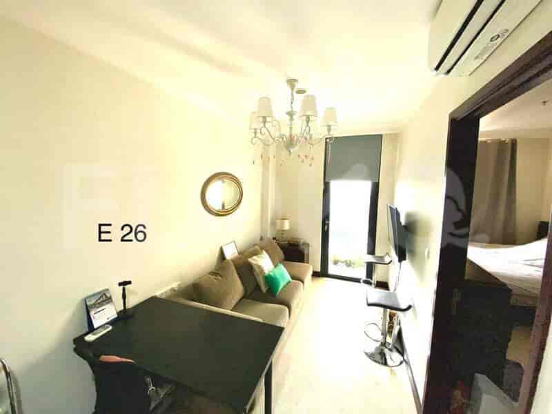 A living area with a sofa, small table, and a chandelier.