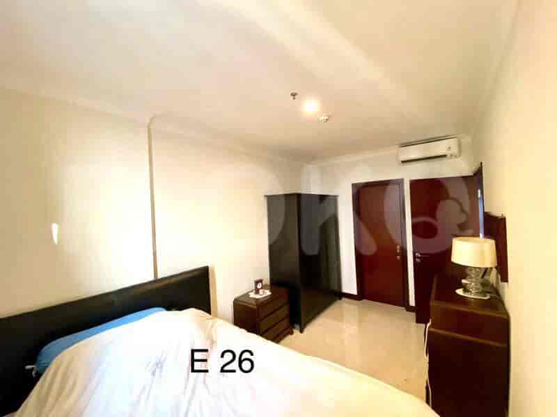 A bedroom with a bed, wardrobe, and bedside table.