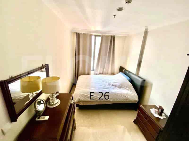 A bedroom with a double bed, a mirror and dresser.