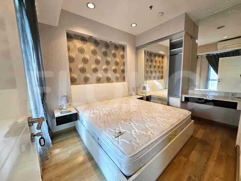 Bedroom with a queen-size bed, patterned wallpaper, mirrored closet, and vanity area.