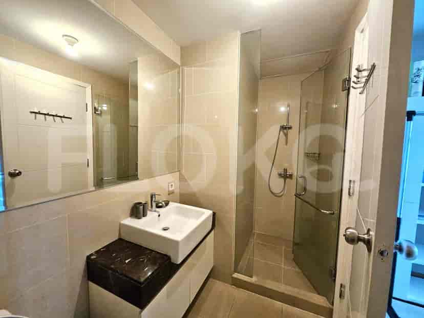Modern bathroom with a square sink, glass-enclosed shower, and tiled walls.