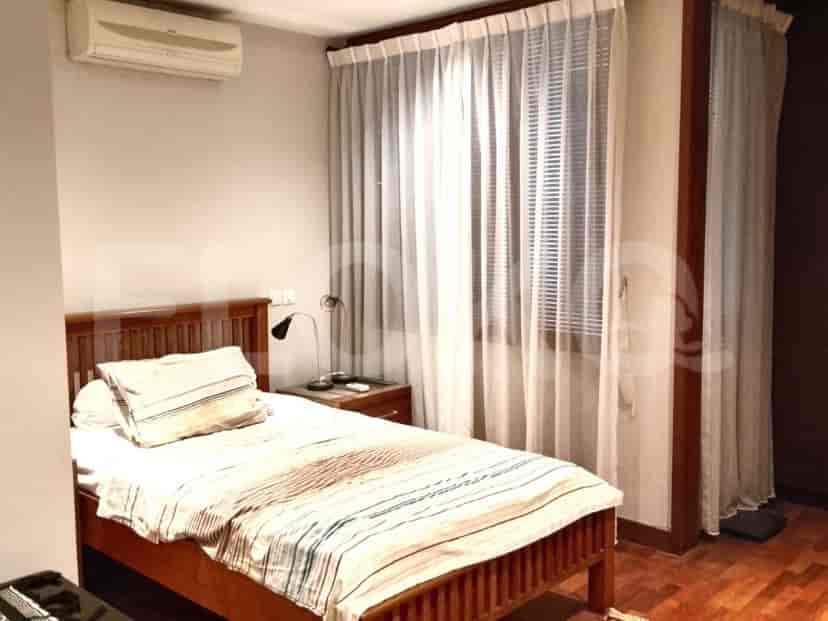 Kamar tidur dengan tempat tidur tunggal, tirai tipis putih, dan unit pendingin udara.
