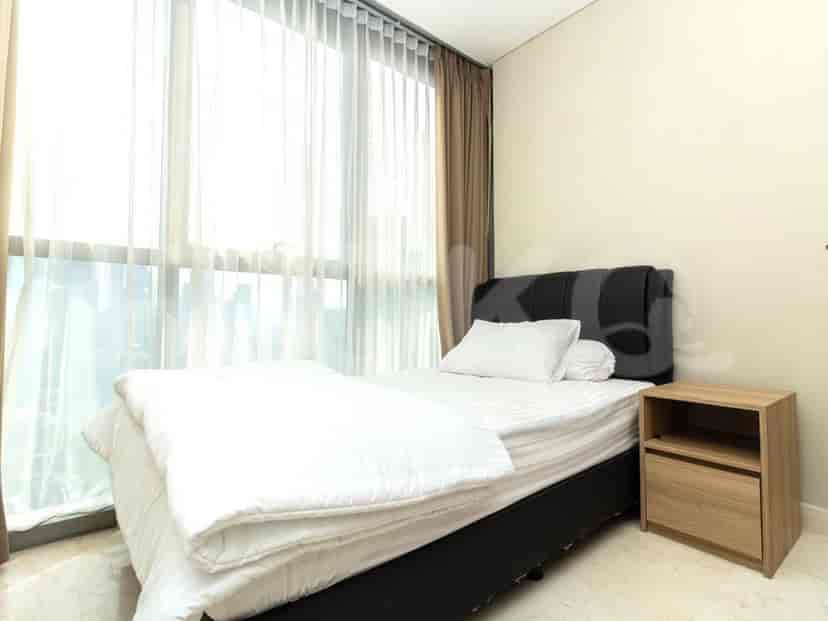 A cozy bedroom with a queen-sized bed, a bedside table, and a large window with sheer curtains.