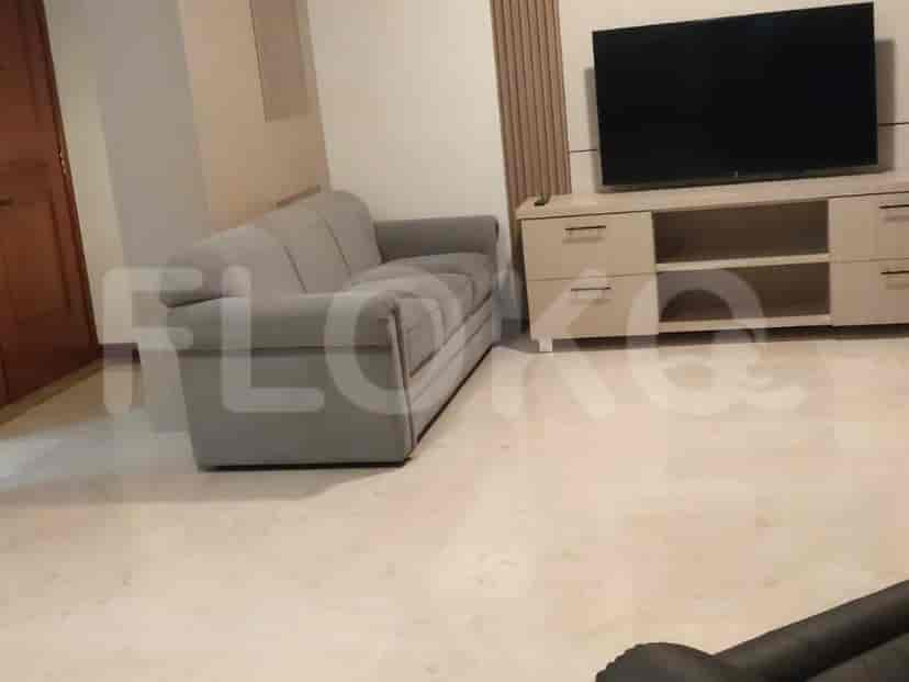 Living room with a grey sofa and a TV console.