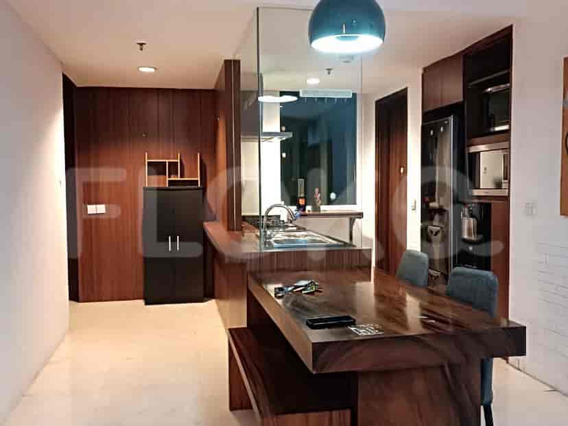 A modern kitchen with wooden cabinets, a dining table with benches, and kitchen appliances.