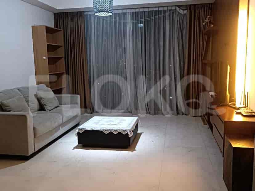 A modern living room with a grey sofa, ottoman coffee table, and a large window with curtains.